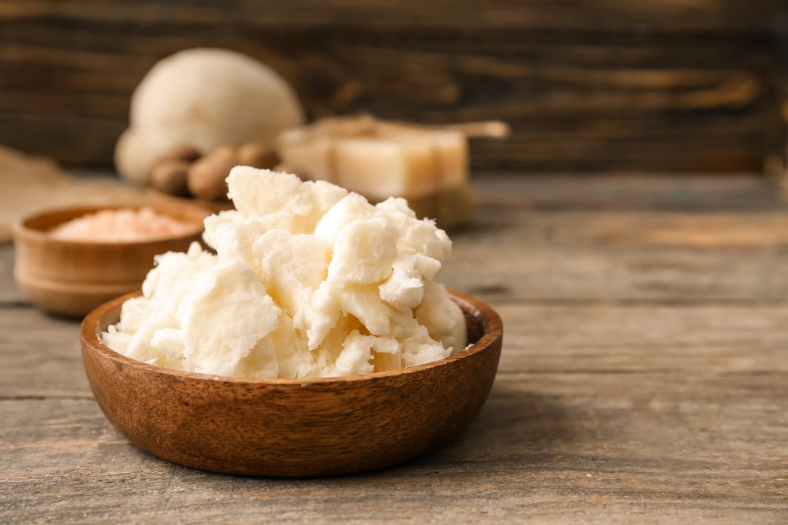 Bowl with Shea Butter on Wooden Background